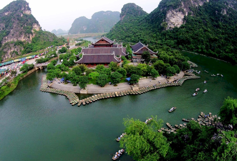 Ride through tranquil waters framed by glowing leaves and misty cliffs